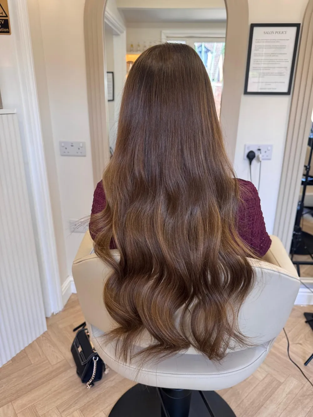 Long, voluminous chocolate-brown hair extensions with soft waves